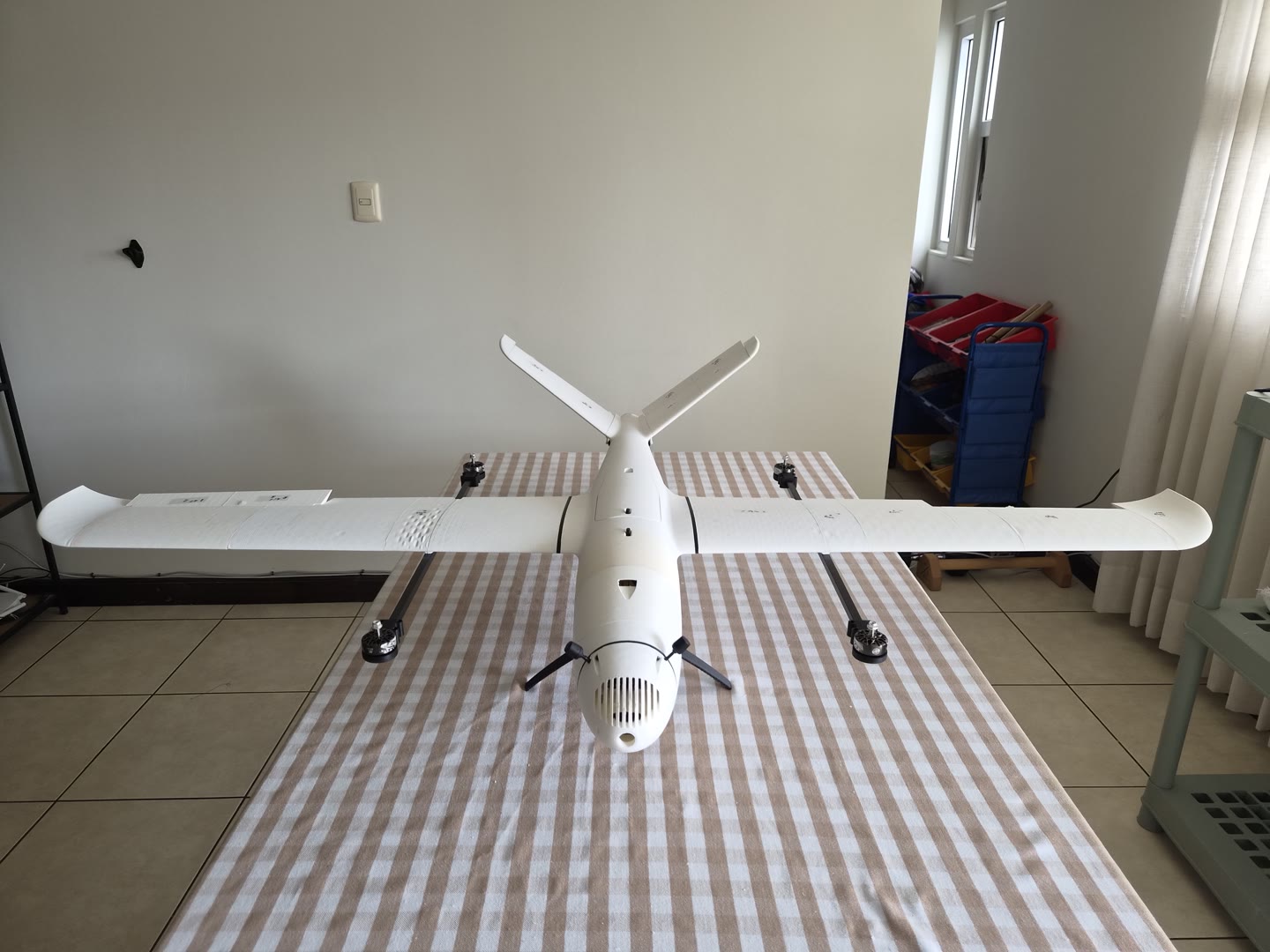 El Stork terminado sobre la mesa, visto de frente: el ala completa, la cola en V y las dos vigas con los cuatro motores de sustentación, todavía sin hélices.